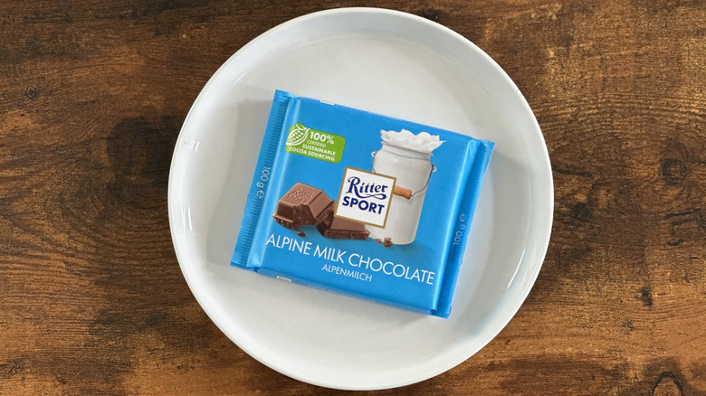 package of Ritter Sport Alpine Milk Chocolate on white plate on wooden table