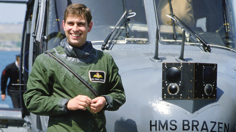 A pitcure of a younger Prince Andrew standing in front of a green helicopter