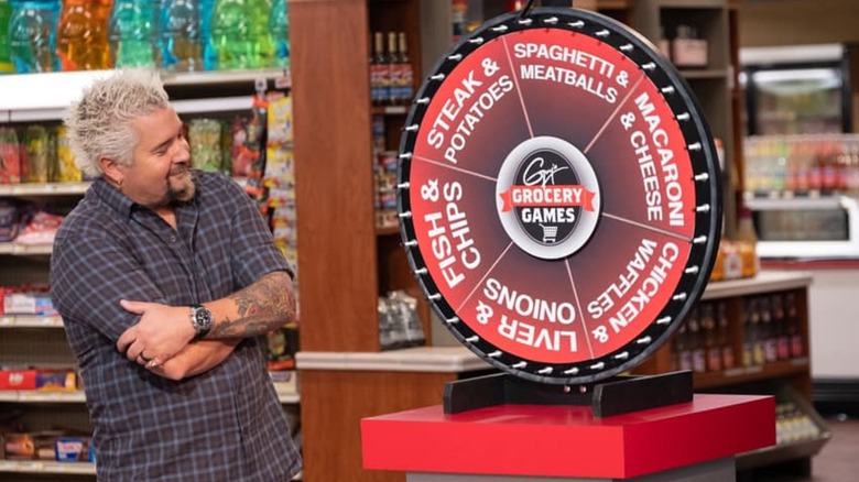 Guy Fieri in front of the "Food Wheel" on Guy's Grocery Games
